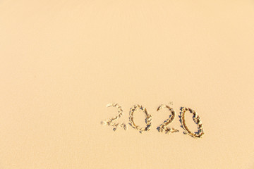Summer beach holiday 2020 season golden sand - old year - decade - new season lettering on the beach - Numbers 2020 year on the sea shore, message handwritten New Years concept copy empty space