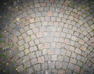 Paving stones pathway texture with sprouting green grass between the stones