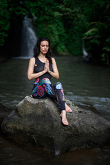 Yoga practice and meditation in nature. Woman practicing near river