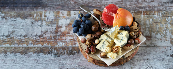 Mix of cheeses, nuts and fruits. Healthy snack. Appetizer to wine. Selective focus.