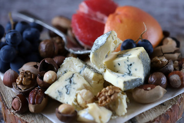 Mix of cheeses, nuts and fruits. Healthy snack. Appetizer to wine. Selective focus.