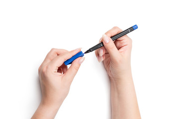 Female hands holding a marker with a cap, isolated on white background. File contains a path to isolation.