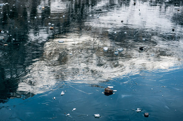 Reflections of the Blümlisalp Mountains on frozen Lake Oeschinensee in the Swiss Alps