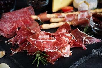 Tasty prosciutto served on grey table, closeup