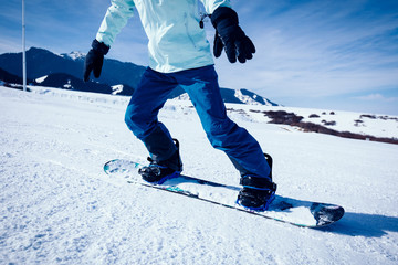 One snowboarder snowboarding in winter mountains