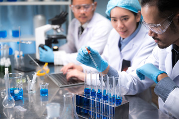 asian scientist hold a test tube filled with liquid in the laboratory