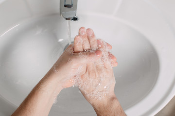 Wash hands under the tap with soap. Hygiene concept in detail. Beautiful stream of hands and water...