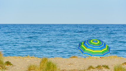 Colorida sombrilla en una playa del mar Mediterráneo