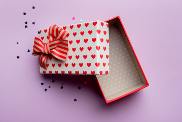 Fototapeta premium Gift box with beautiful red ribbon on a pink background
