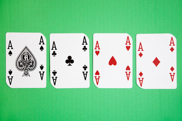 Four aces playing cards over green surface