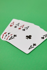 Four aces playing cards over green surface