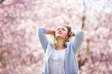 Young woman enjoying the nature in spring. Dancing, running and whirling in beautiful park with...