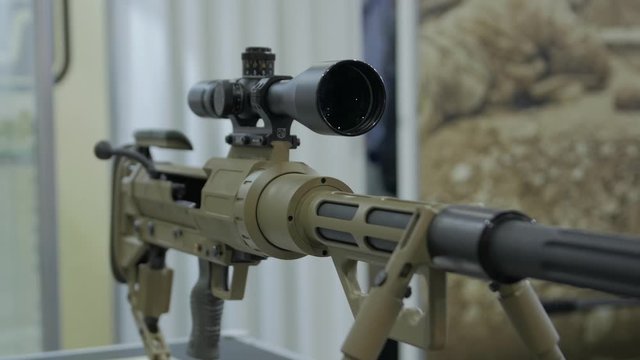 Modern sniper rifle weapon with an optical sight military green camouflage camera movement