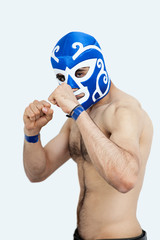 Portrait of a young shirtless male wrestler over gray background