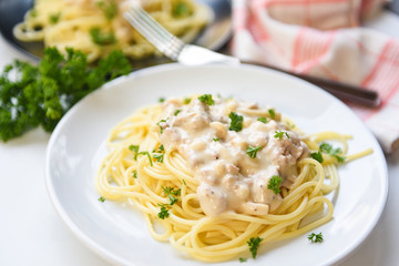 Spaghetti italian pasta served on white plate with parsley in the restaurant italian food and menu concept - spaghetti carbonara top view