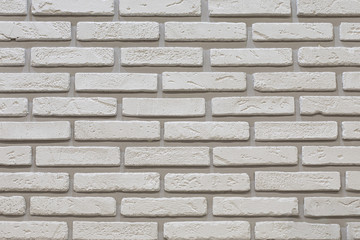 White brick wall with shabby grain brick. Decorative wall decoration with stone, backdrop texture background. Wall of white thin smooth brick texture effect