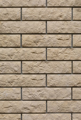 Fototapeta premium Brick wall with uneven rough beige brick. Decorative wall decoration with brick stone, texture background backdrop. Wall of smooth brick textured effect