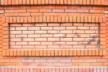 Fototapeta premium Background of an old brick wall with a frame in the center, copy space for text