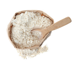 Organic flour and spoon in paper bag isolated on white, top view