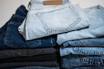 A pile of folded jeans in blue Background of clothing in indigo