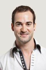 Fototapeta premium Close-up portrait of young man smiling over gray background