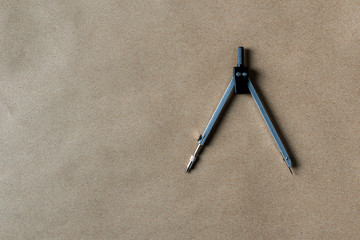 drawing compass on brown paper.