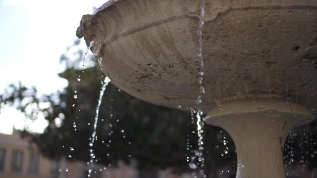 Fuente de piedra en una plaza con chorros de agua HD