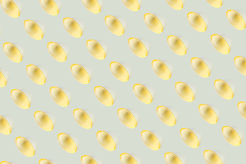 Transparent yellow vitamin capsules on a light pastel background. The concept of health, beauty. Vitamin E, omega-3, vitamin D3, fish oil. Top view, minimalism, copy space.
