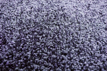 The curly texture of the fibers of the carpet a dark color, background