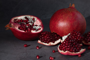 Ripe pomegranate fruits on a dark background