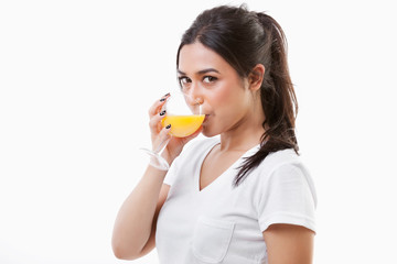Portrait of young Asian woman drinking orange juice over white background
