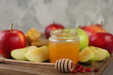 Honey, apples and pomegranate on wooden board, closeup. Rosh Hashanah holiday