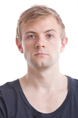 Portrait of serious young man in blue tshirt against white background
