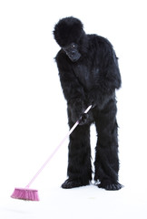 Young man in gorilla costume sweeping the floor over white background