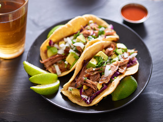 mexican carnita street tacos with beer on slate table setting