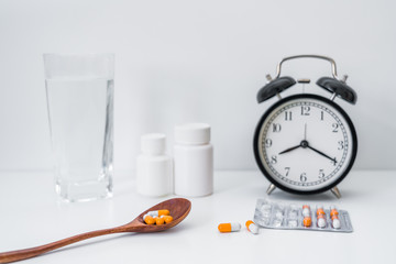 A bottle of water, bottles and capsules in white background	