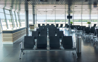 Empty waiting hall in airport with lounge area.
