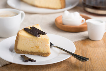  Delicious slice of new york cheesecake with word  on white background. Sweet and tasty food, coffee break concept. Classic american dessert.