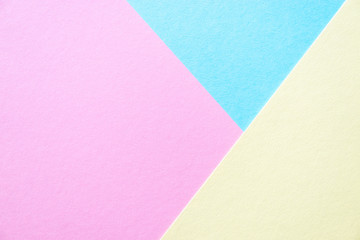 Lilac, soft pastel yellow and blue colored textured paper for the background. Geometric empty paper background of three tones for copy space.