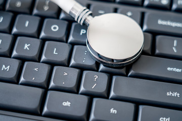 Stethoscope on black computer keyboard with network information leak concept