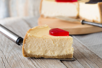 Delicious slice of new york cheesecake on  grey background, isolated. Sweet and tasty food, coffee break concep. Classic american dessert.