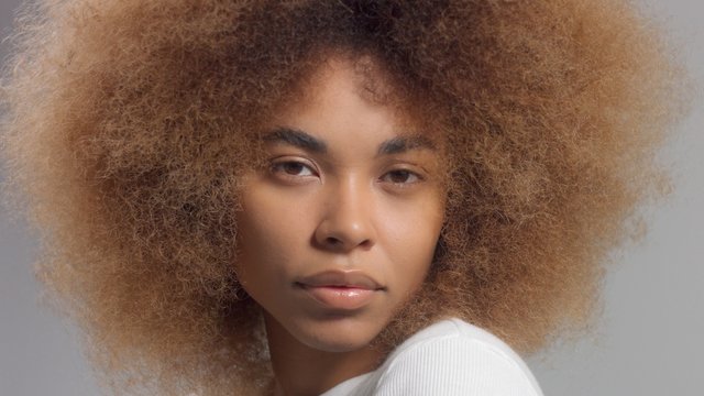 Mixed Race Black Woman With Big Afro Hair In Studio Closeup Portrait Watching To The Camera No Makeup Portrait