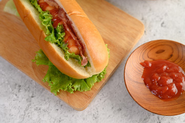 Hotdog with lettuce and tomato sauce on Wood cutting board  wood cutting board