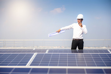 Solar power plant. Engineer & Manager with radio communication  on photovoltaic panels, on building roof ,  Renewable energy Concept