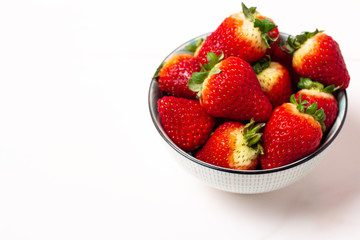 fresh strawberries in a bowl on white