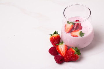 glass with yogurt and fresh berries on a white background and place for text