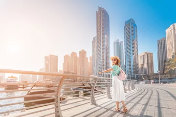Crédence de cuisine en verre imprimé Dubai Cheerful asian traveler girl walking on a promenade in Dubai Marina district. Travel destinations and tourist lifestyle in UAE