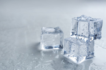 Crystal clear ice cubes on grey background, closeup. Space for text