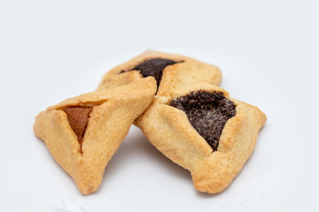 ozenei haman, Jewish holiday pastry, for Purim holiday. Crispy dough stuffed with chocolate, halva or poppy flavored stuffing. Isolated on a white background