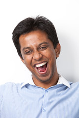 Fototapeta premium Portrait of cheerful young Indian man against white background